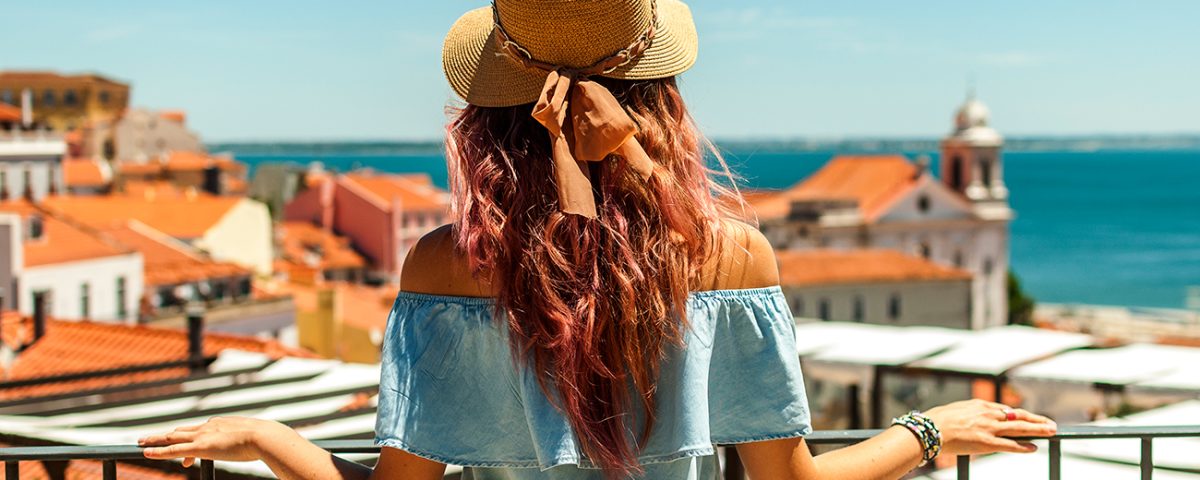 Moça observando o horizonte de uma cidade portuguesa.