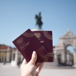 Pessoa segurando passaportes portugueses em Lisboa.